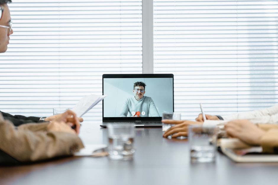 A diverse group participates in a virtual meeting using modern technology.